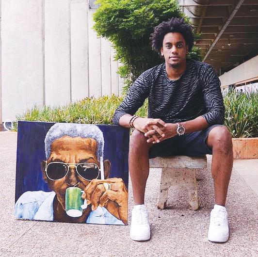 Muha Bazila poses with one of his portraits.