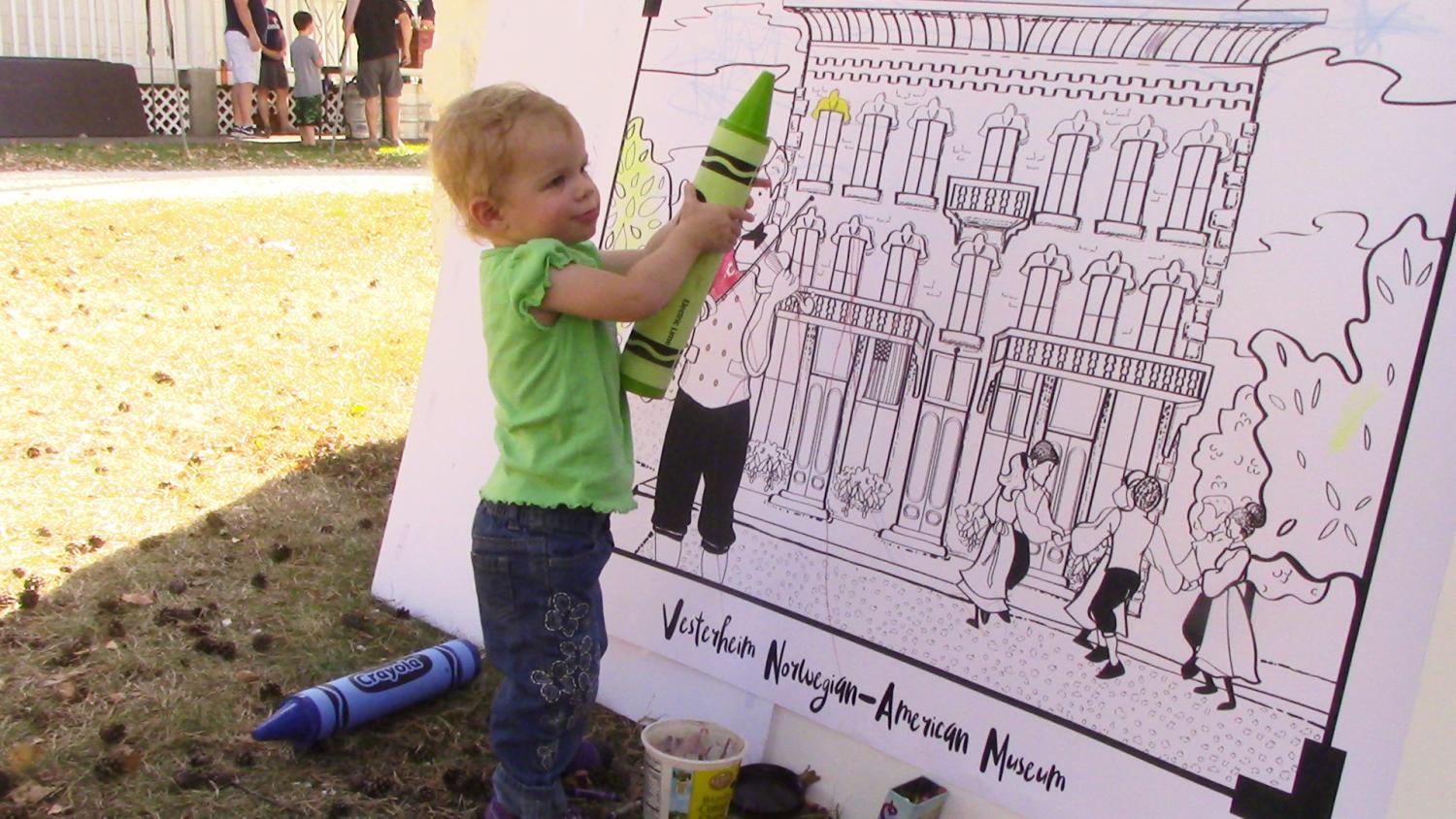Nina Peterson, daughter of Assisstant Professor of History Anna Peterson, colors in the giant coloring book.