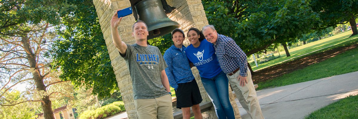 Luther Ambassadors Grant Preheim ('18), Sam Poppen ('18), and Harleigh Boldridge ('18) pose with Cross Country Assistant Coach Kirk Neubauer.