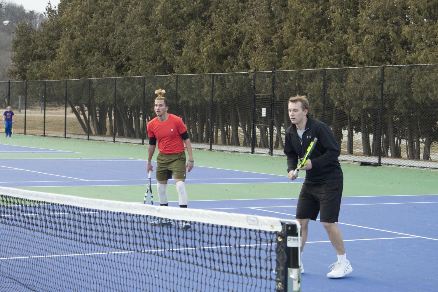 Sakchham Karki (‘21) and Brian Murman (‘19) practice doubles on the tennis courts.