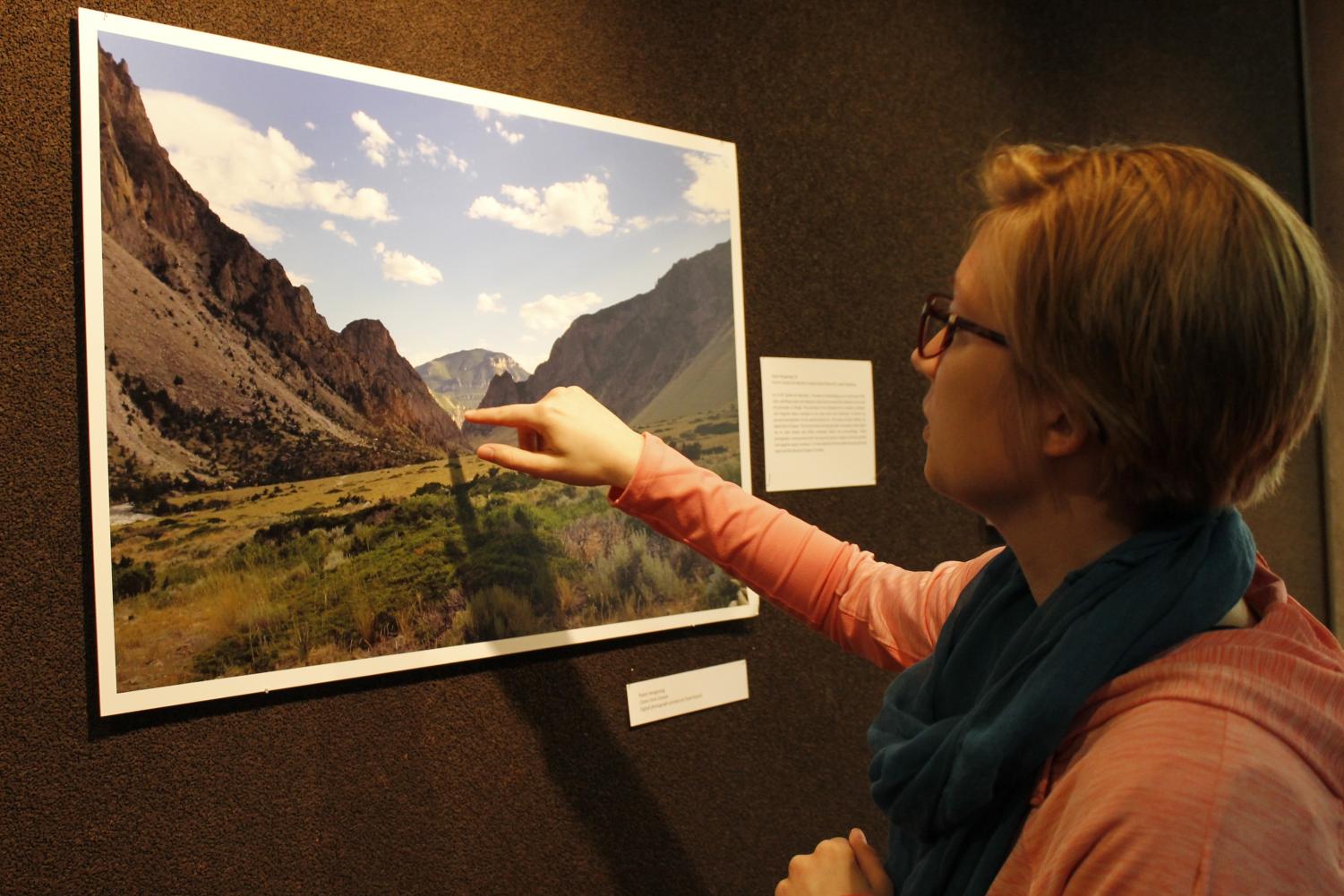 Steffenee Voigt (‘18) locates the focal point of Robin Schone Hengesteg’s (‘16) “Clarks Fork Canyon” on display in Preus Library.