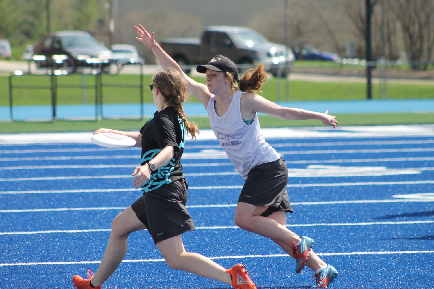Cora Egherman (‘19) attemps to throw a frisbee as Alexis Hove (‘18) defends.
