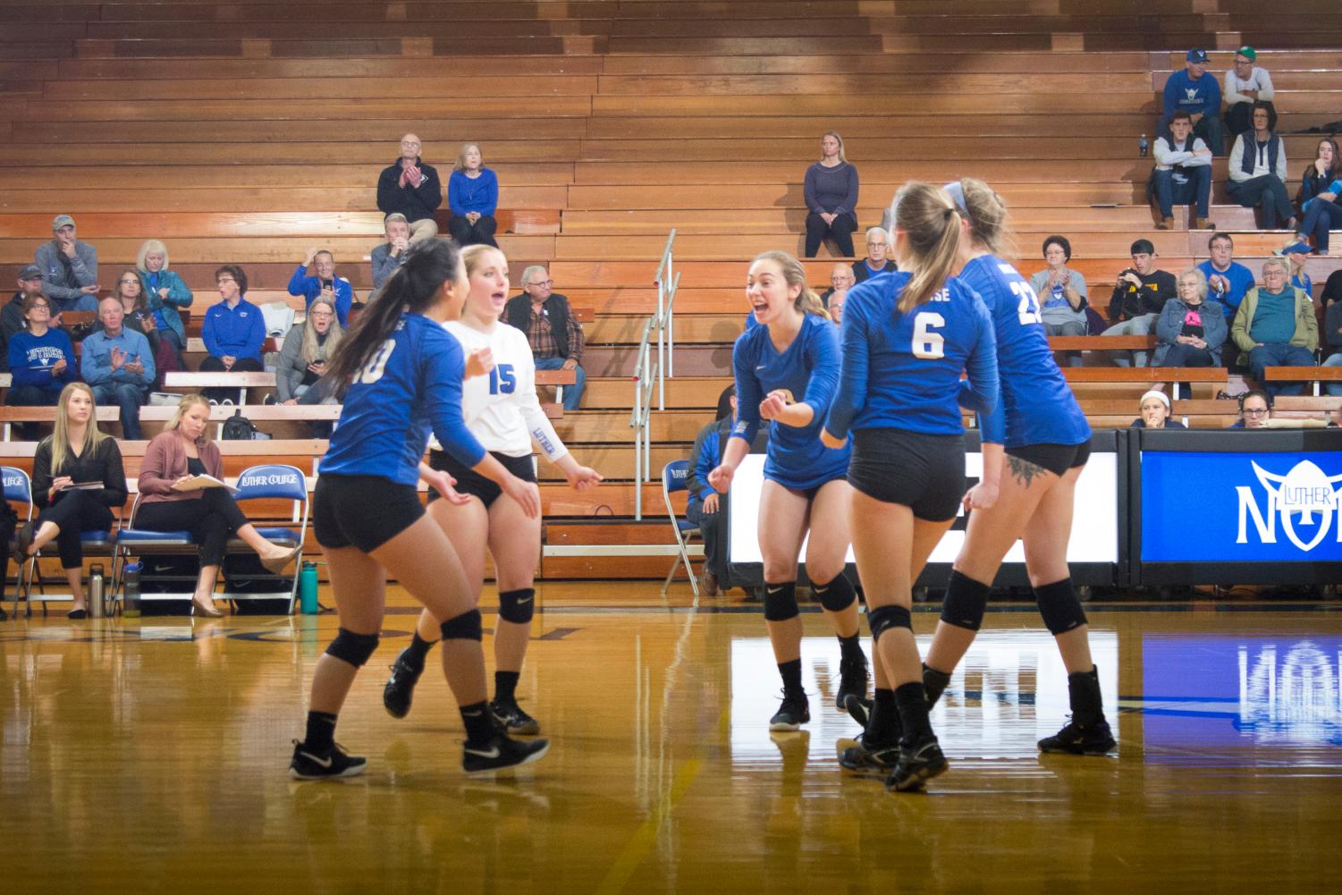 Grace Meyers (‘22), Natalie Cote (‘19), Anna Larson (‘19), Katie Shabatura (‘19), and Sam Sixta (‘20) celebrate after a point against Loras College on Oct. 30.
