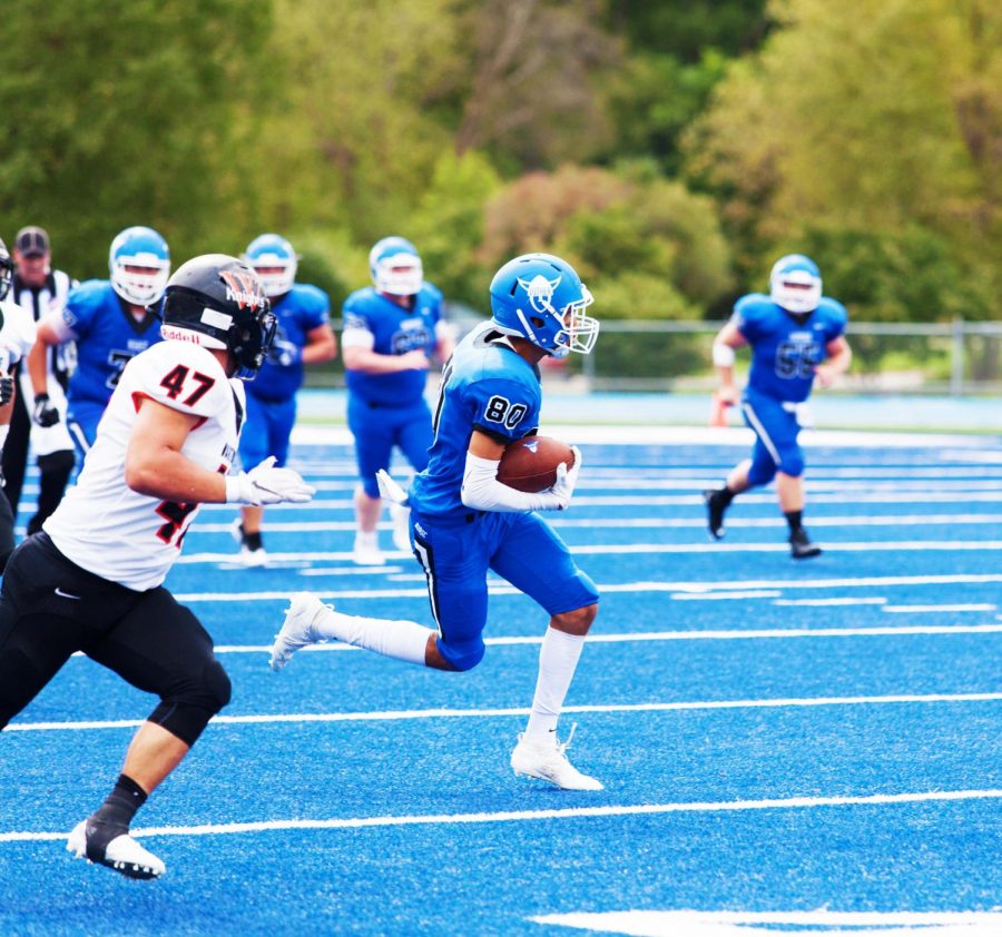 Andrew Atkins (22) runs through the Wartberg defense.