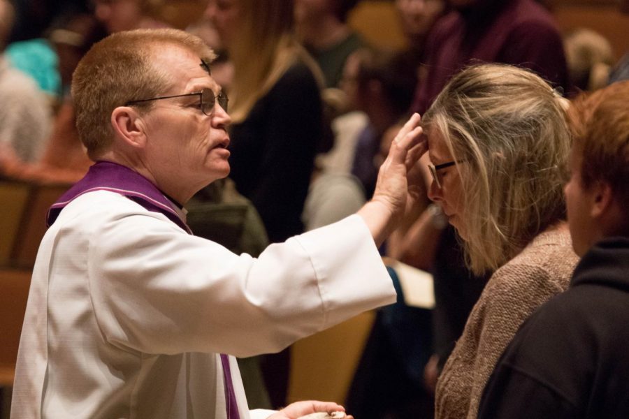 College Pastor Mike Blair places ashes on parishioners foreheads on Ash Wednesday in 2018.