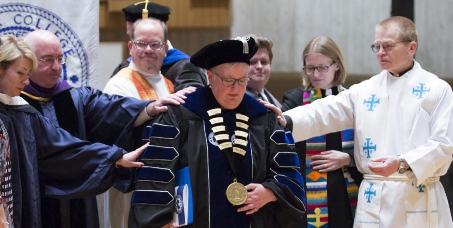 Members of the stage party lay a hand on President Ward during the Prayers of Intercession.