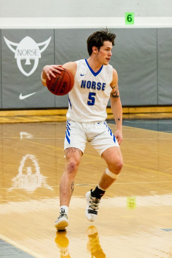  Gage Thompson (21) dribbles the basketball during a game against Central College on February 10.