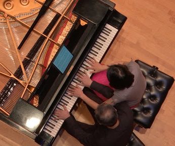 Professors Du Huang (left) and Xiao Hu (right) perform duet on the same piano. Photo Courtesy of Mick Layden.