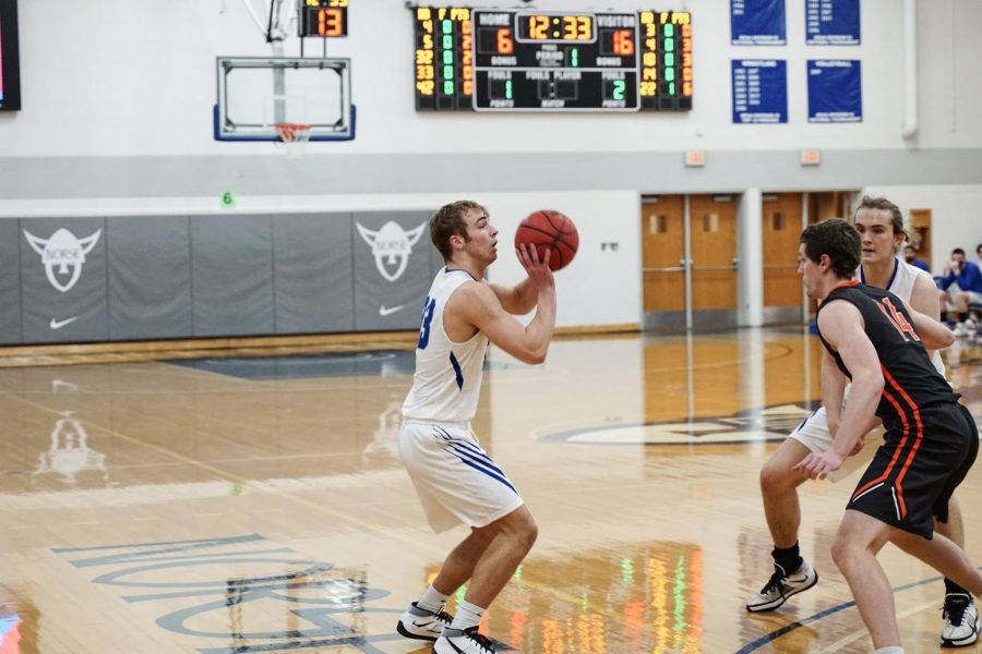 Matthew Franzen (‘24) shoots a three-pointer during a game on February 22 against Wartburg. 