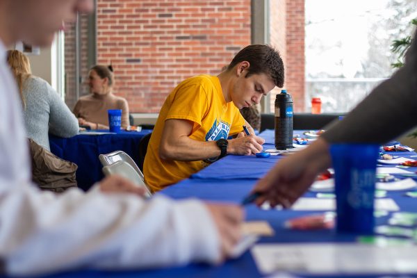 Tom Altier (23) writes a thank you note to a scholarship donor during Philanthropy Week in November 2022. Photo courtesy of Armando Jenkins-Vazquez (21)/Luther College Photo Bureau