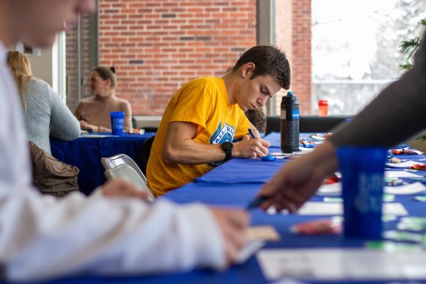 Tom Altier ('23) writes a thank you note to a scholarship donor during Philanthropy Week in November 2022. Photo courtesy of Armando Jenkins-Vazquez ('21)/Luther College Photo Bureau