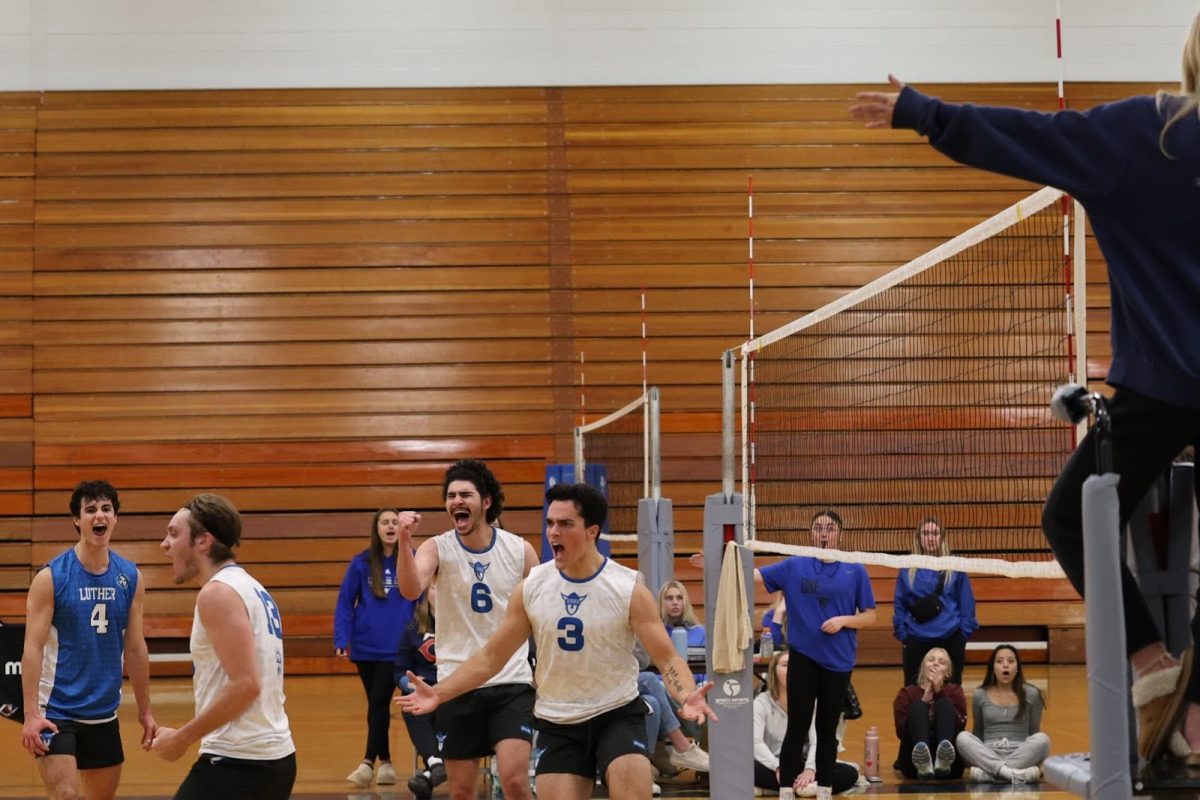 Finn Wallace (25, #3) celebrates winning a point with the rest of the Luther Mens Volleyball team. Photo courtesy of Luther Mens Volleyball.