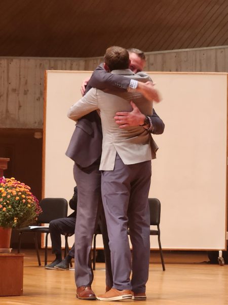 Gene Adams and Dave Mitchell embrace.