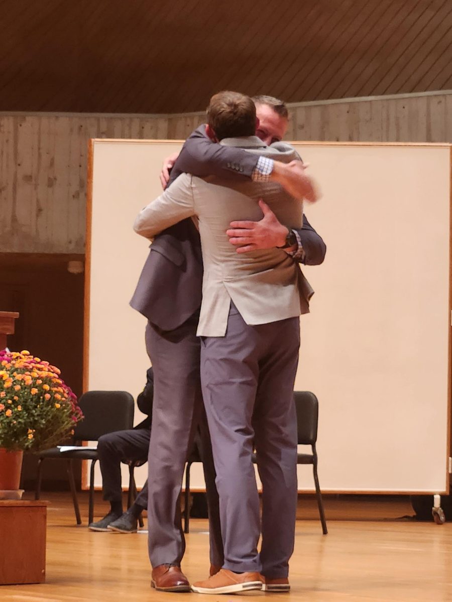Gene Adams and Dave Mitchell embrace.