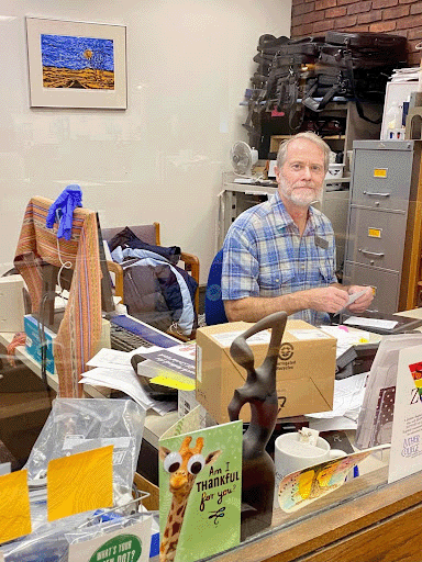 Eddy Atwell, the circulation desk supervisor at Preus Library for more than thirty years, sits in his office in December 2024. Photo courtesy of Faneeza Malik. 